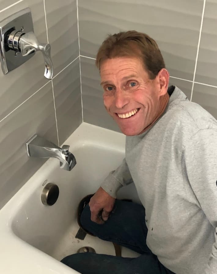 Jeff Schefer, owner of Jeff Schefer's Plumbing Service, working on a bathtub faucet in Santa Rosa