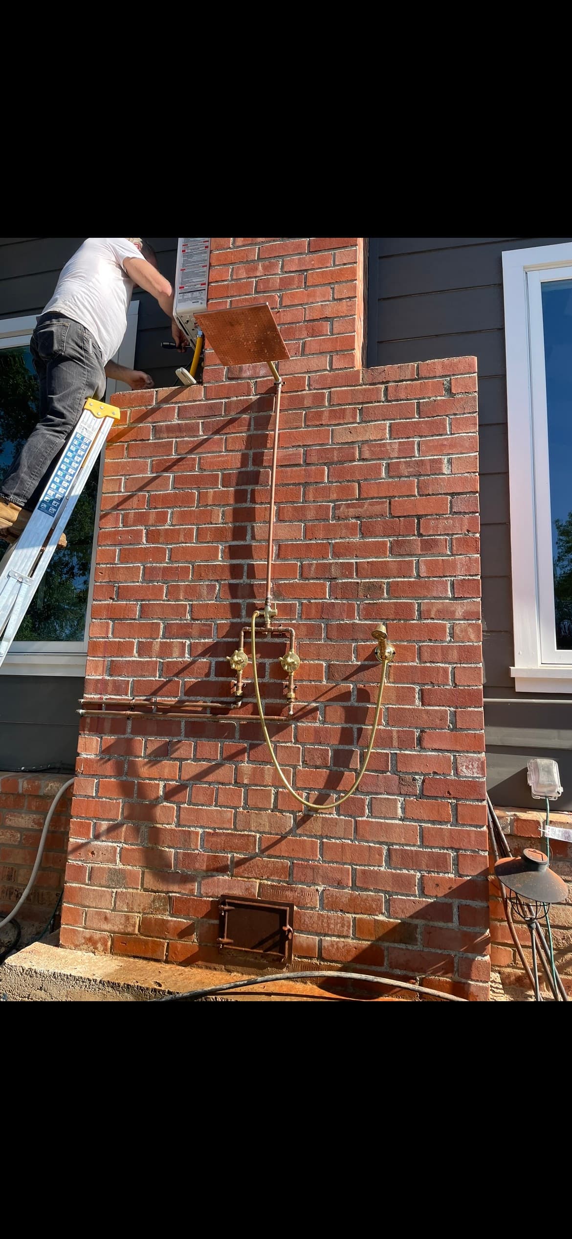 Tankless water heater installation on an exterior brick wall in Santa Rosa